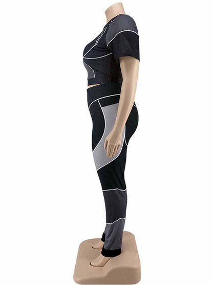 Schwarzes und graues Damen-Sportset, kurzärmeliges Oberteil und Leggings, seitliche Ansicht.