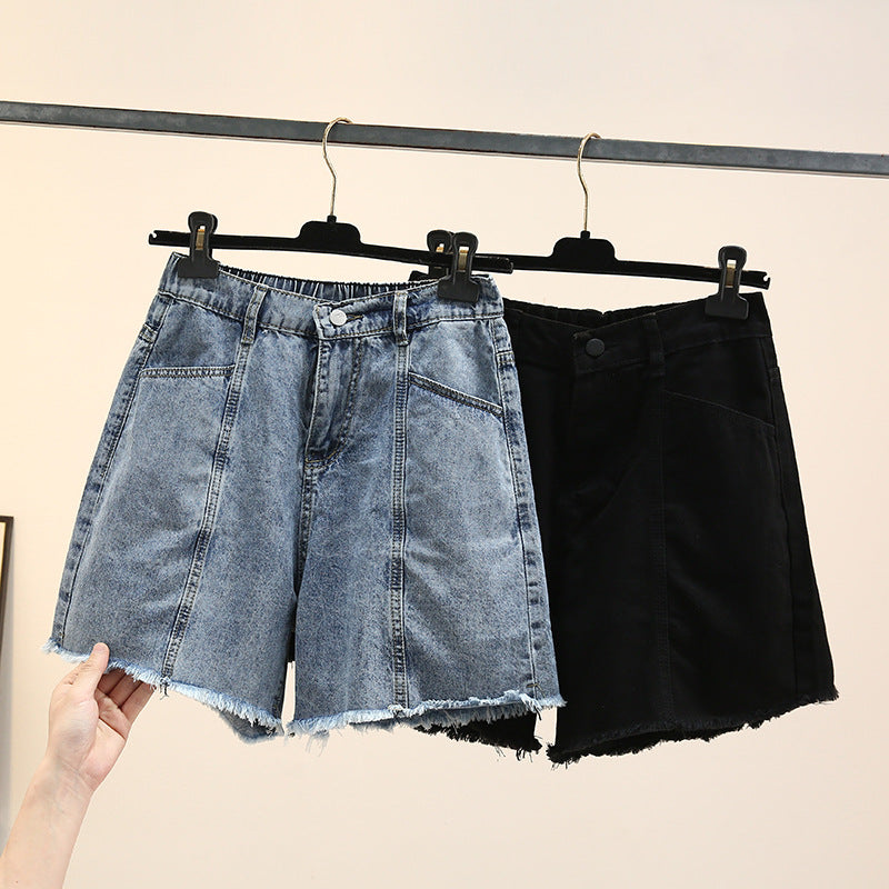 Zwei Damen-Jeansshorts, blau und schwarz, auf Kleiderbügeln, modisch, lässig.