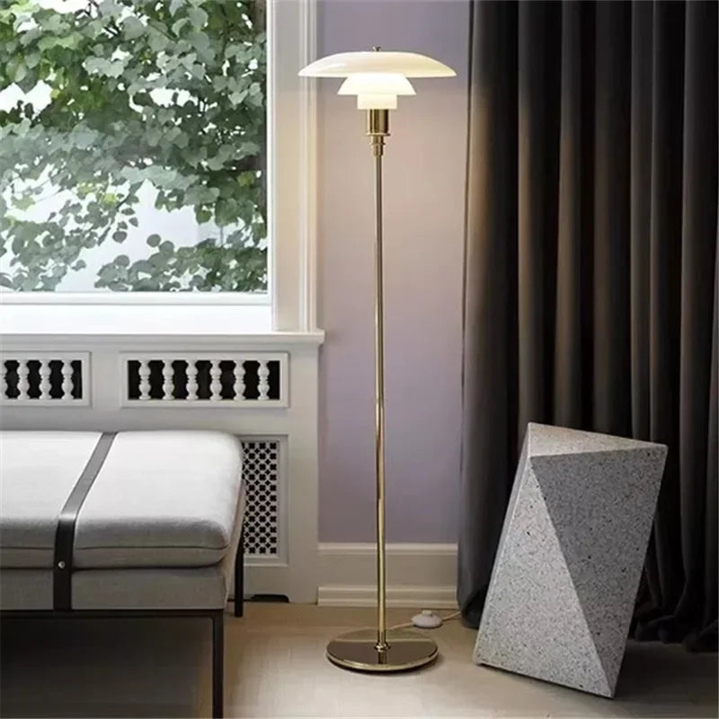 Stehlampe aus Messing mit weißem Schirm, modernes Design, Wohnzimmer, neben Sofa.