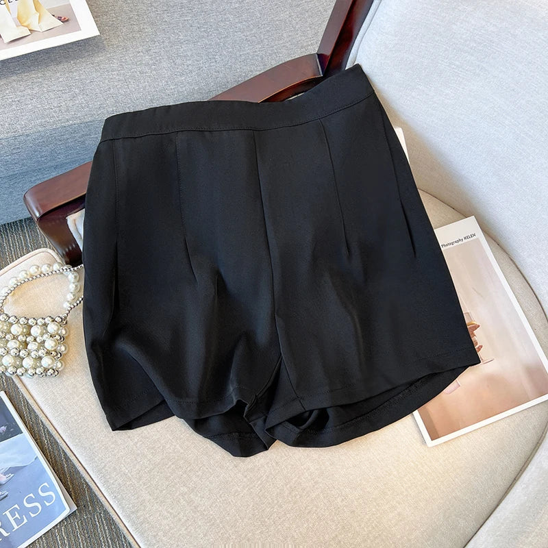Schwarze Damen-Shorts aus Baumwolle auf grauem Sessel, elegant, modisch, Sommerkleidung.