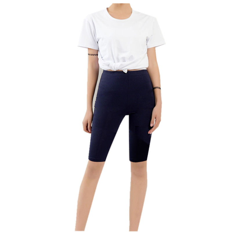Frau in weißem T-Shirt und dunkelblauer Radlerhose, Freizeitmode, Sommeroutfit.
