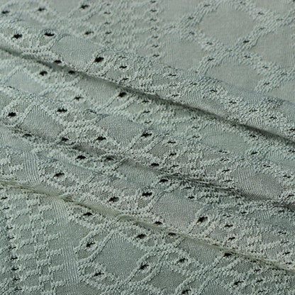 Grauer Jacquardstoff mit geometrischem Muster, ideal für elegante Bekleidung und Heimtextilien.