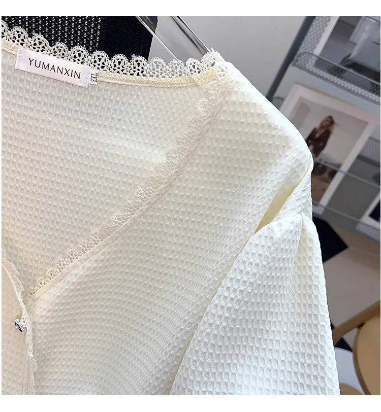 Weiße Damenbluse aus Waffelstoff mit Spitzenbesatz, elegant und stilvoll für Büro oder Freizeit.
