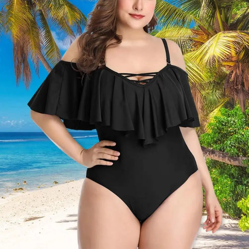 Frau im schwarzen Badeanzug am tropischen Strand mit Palmen und blauem Meer.