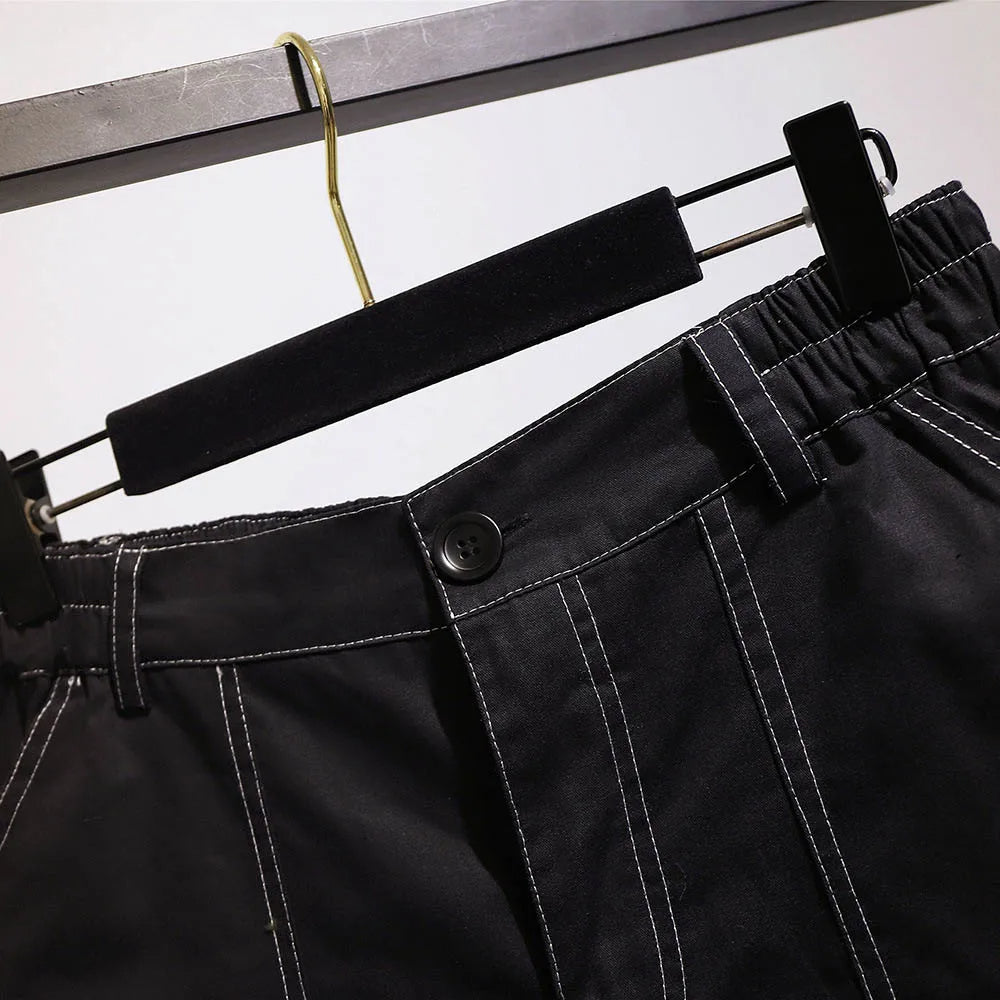 Schwarze Herrenhose mit weißen Nähten, elastischer Bund, auf Kleiderbügel.