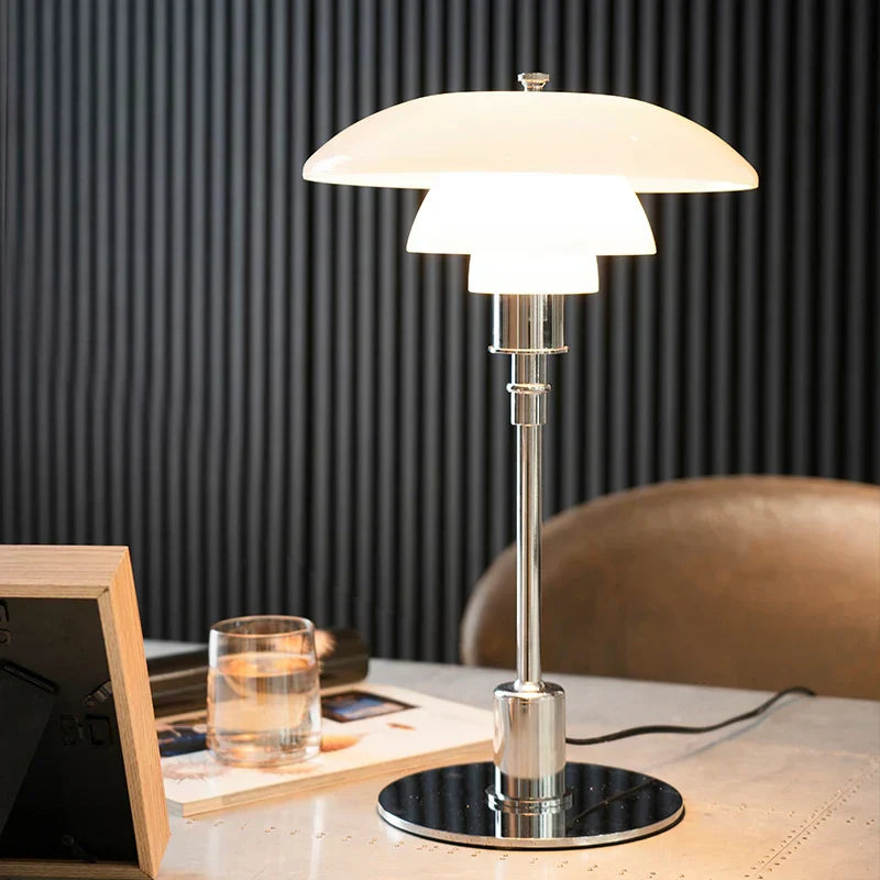 Moderne Tischlampe aus Metall mit weißem Schirm auf Schreibtisch, elegantes Design.