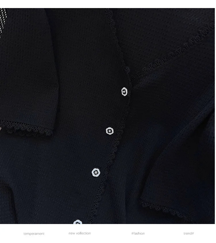 Schwarze Damenbluse mit Spitzenbesatz und weißen Knöpfen, elegante Mode, neue Kollektion.