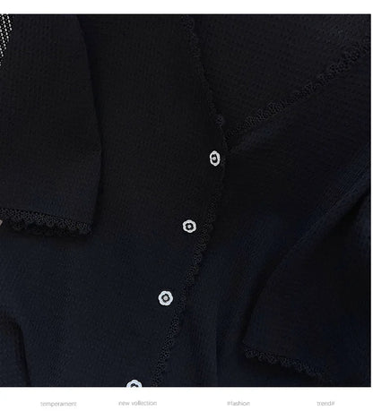 Schwarze Damenbluse mit Spitzenbesatz und weißen Knöpfen, elegante Mode, neue Kollektion.