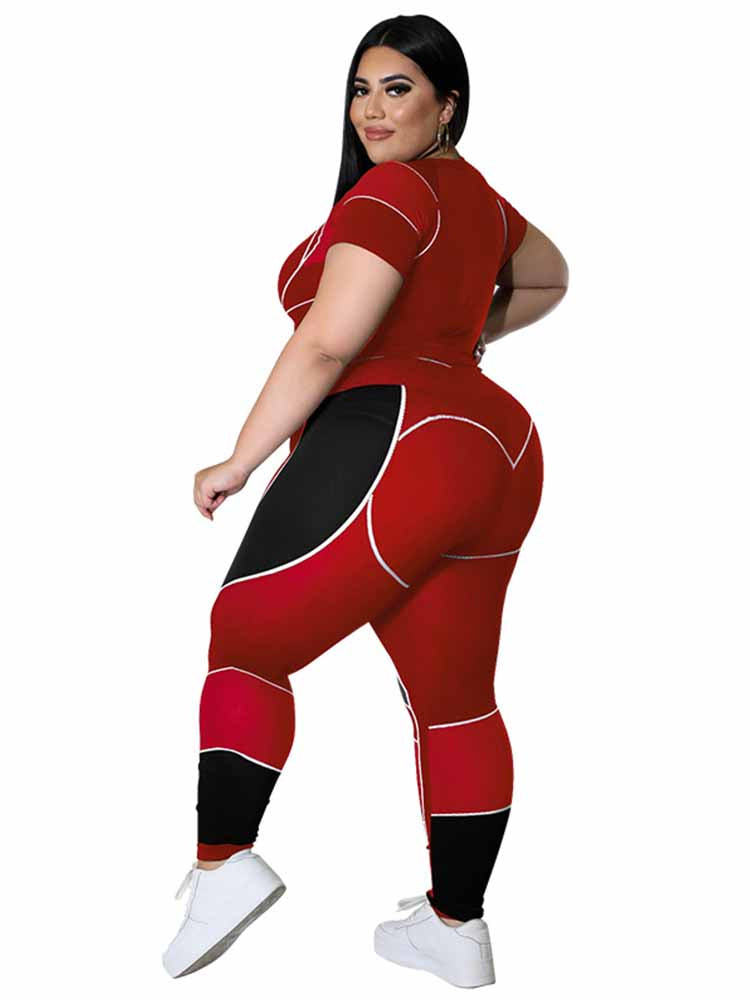Frau in rotem, figurbetontem Sportanzug, Plus-Size-Mode, schwarze und rote Details, weiße Sneaker.