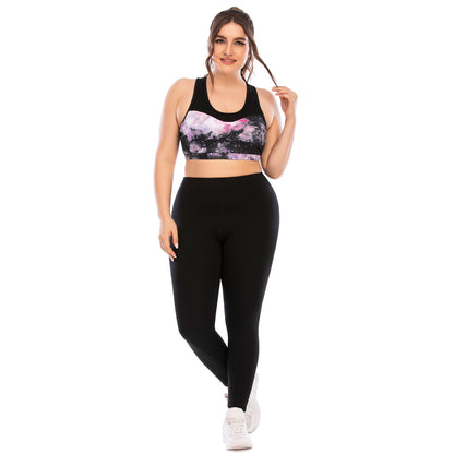 Frau in schwarzer Leggings und bedrucktem Sport-BH, Fitnessmode, Studioaufnahme.