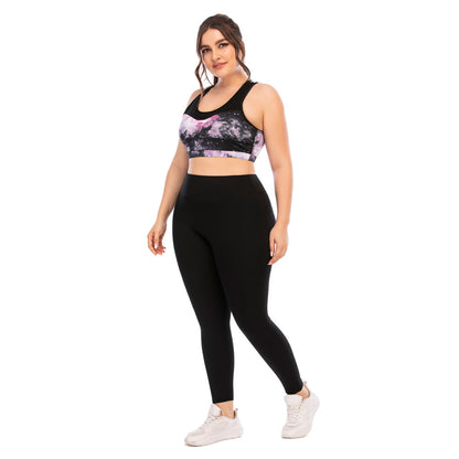 Frau in schwarzer Leggings und lila Sport-BH, Fitnessmode, Plus-Size, Studioaufnahme.