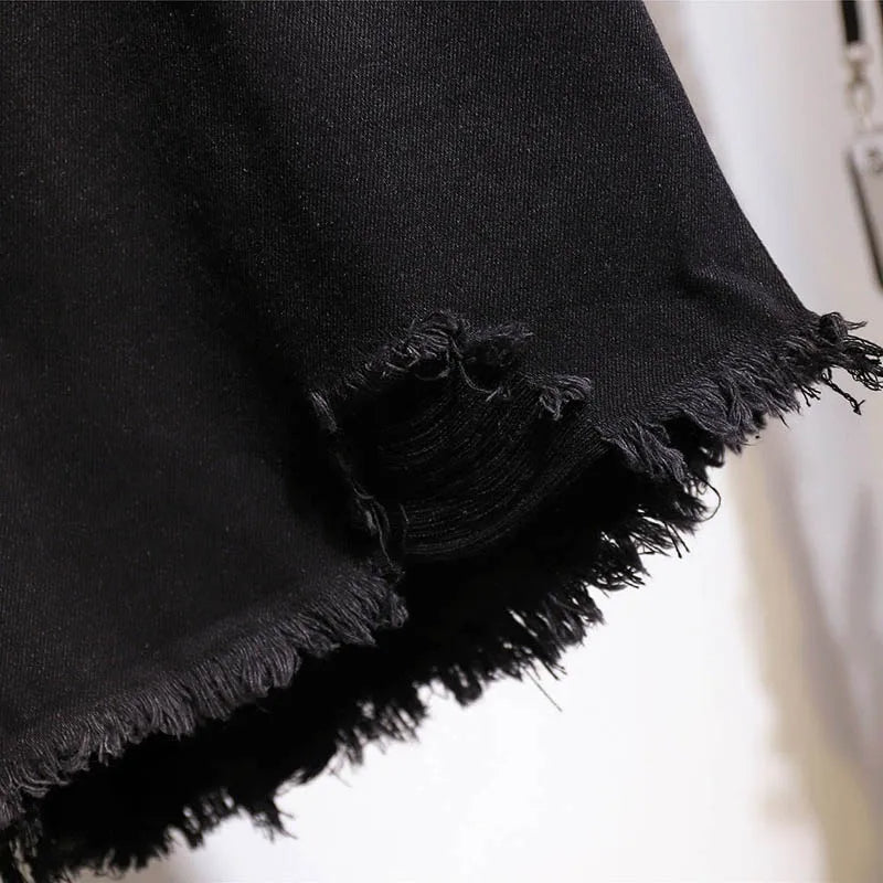 Schwarzer Jeansstoff mit ausgefranstem Saum, Nahaufnahme, Textur, Mode, Detailansicht.