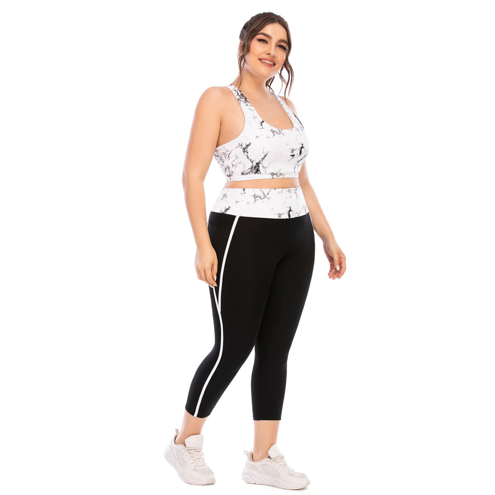 Frau in Sport-BH und Leggings, Marmor-Design, Fitnessmode, Plus-Size, weiß und schwarz.