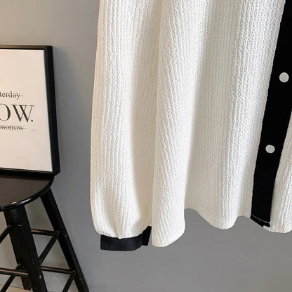 Weiße Strickbluse mit schwarzen Knöpfen, elegantes Design, Damenmode, Herbstbekleidung.