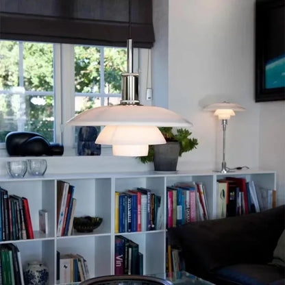Moderne weiße Pendelleuchte im Wohnzimmer, skandinavisches Design, über Bücherregal.