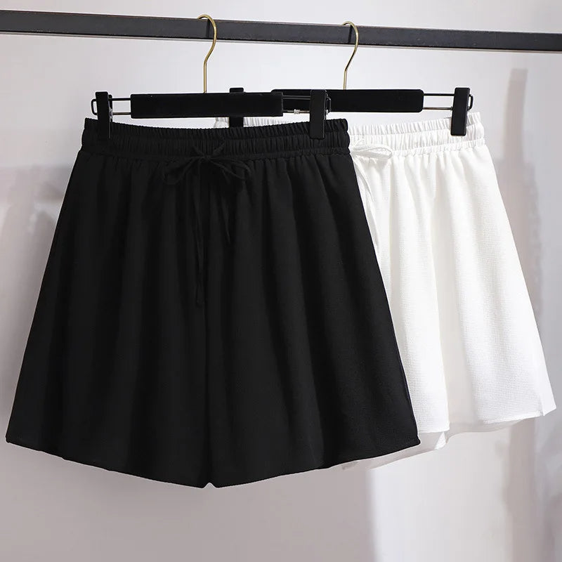 Schwarze und weiße Damen-Shorts aus Baumwolle auf Kleiderbügel, Sommermode, bequem.