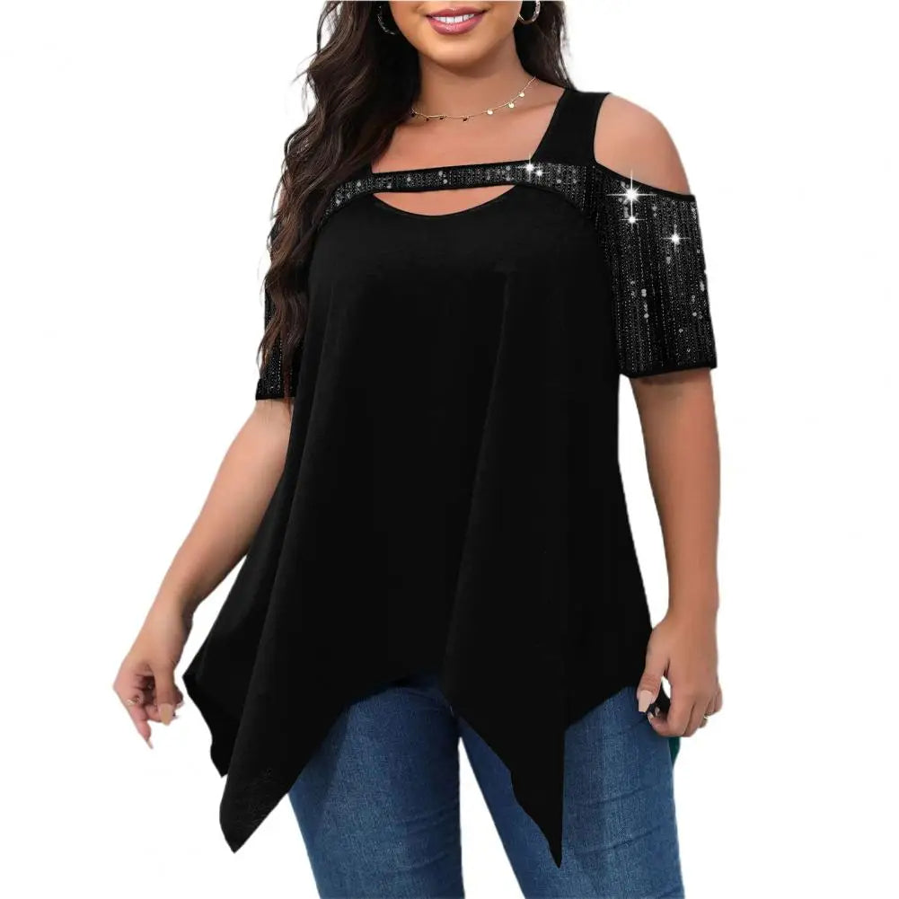 Frau in schwarzer, schulterfreier Bluse mit Paillettenärmeln und blauer Jeans.