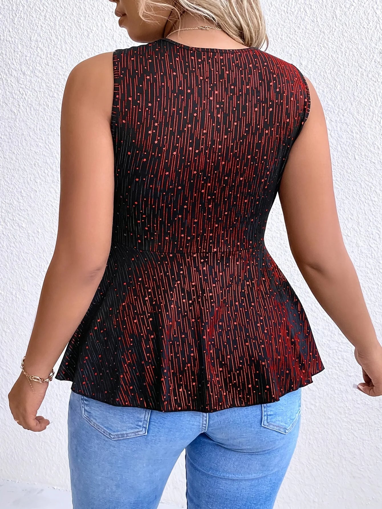 Frau in schwarzer, ärmelloser Bluse mit rotem Muster, Jeans, Rückansicht, Mode, Damenbekleidung.