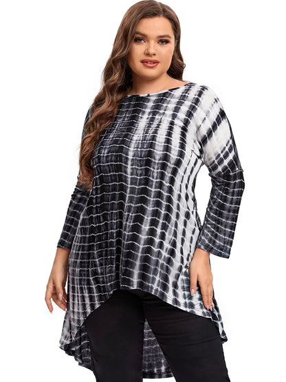 Frau in schwarz-weißem Batik-Longshirt, lange Ärmel, asymmetrischer Saum, Plus-Size-Mode.