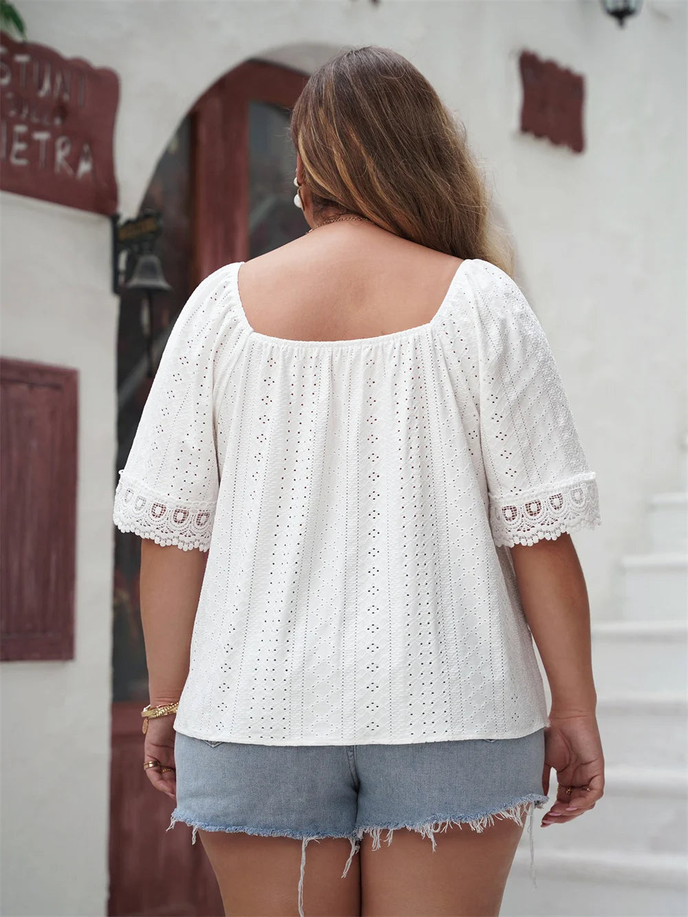 Frau in weißer Spitzenbluse und Jeansshorts, Sommermode, Rückansicht, lässiger Stil