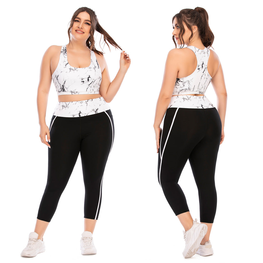Frau in Sportbekleidung, weißes Marmor-Top, schwarze Leggings, Plus-Size, Fitnessmode.