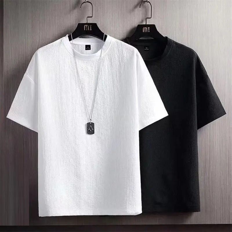 Weiße und schwarze T-Shirts aus Baumwolle auf Kleiderbügeln, modisch, lässig, unisex.