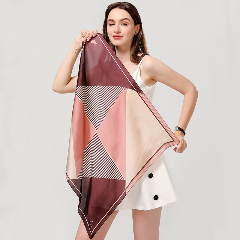 Frau mit geometrischem Seidenschal in Rosa und Beige, modisches Accessoire, elegantes Design.