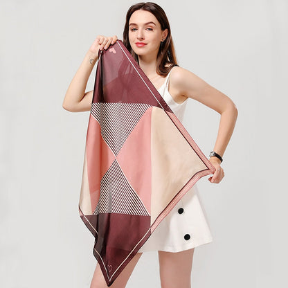 Frau mit geometrischem Seidenschal in Rosa und Beige, modisches Accessoire, elegantes Design.