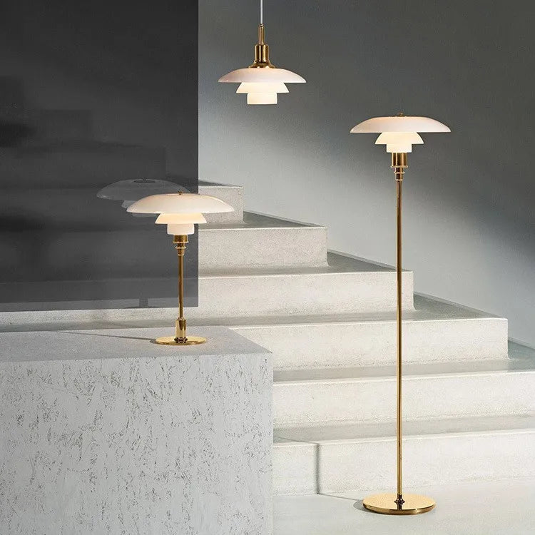Drei goldene Stehlampen mit weißen Schirmen auf Treppe, modernes Design, Innenbeleuchtung.