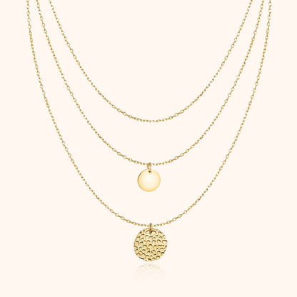 Goldene Halskette mit drei Anhängern, runde Plättchen, elegantes Schmuckdesign, Damenaccessoire.