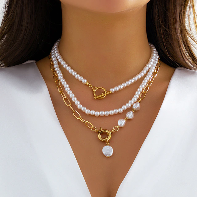 Frau mit dreilagiger Halskette aus Perlen und Gold, eleganter Schmuck, Nahaufnahme.