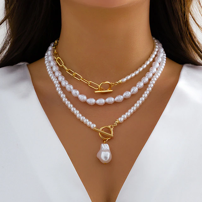 Frau trägt dreilagige Perlenkette mit goldenen Verschlüssen, eleganter Schmuck, Nahaufnahme.