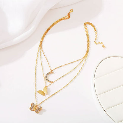 Goldene Halskette mit Schmetterling, Mond und Herzanhänger, Damen Schmuck, modisch, elegant.