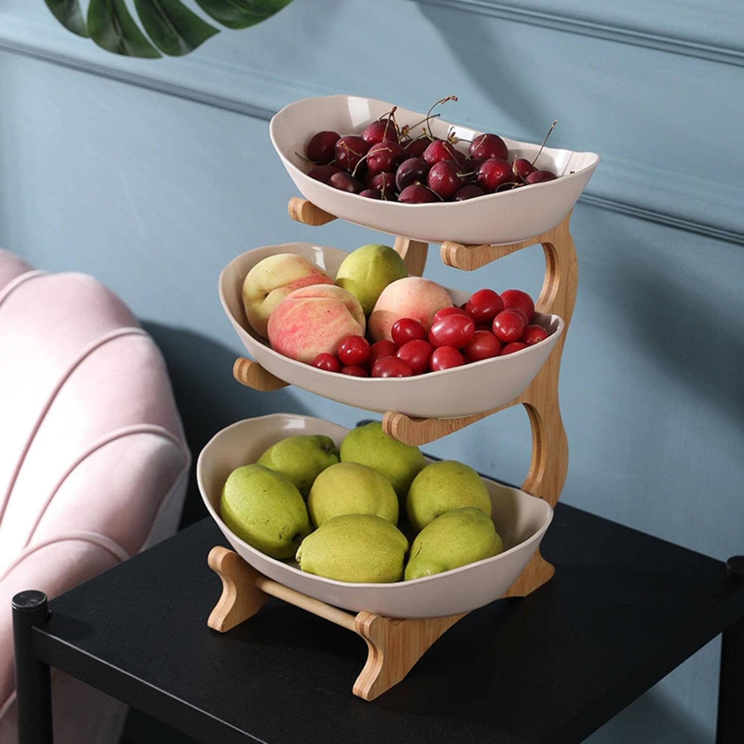 Dreistöckige Obstschale aus Keramik und Holz, gefüllt mit Kirschen, Äpfeln und Birnen.