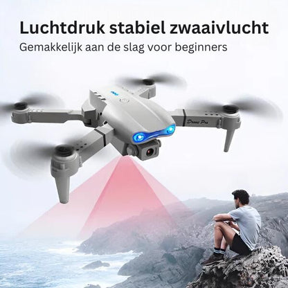 Graue Drohne mit Kamera, LED-Leuchten, faltbar, ideal für Anfänger, fliegt über Küste.