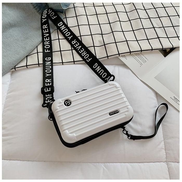 Weiße Mini-Kofferhandtasche für Damen, mit schwarzem Schultergurt, modisch und kompakt.