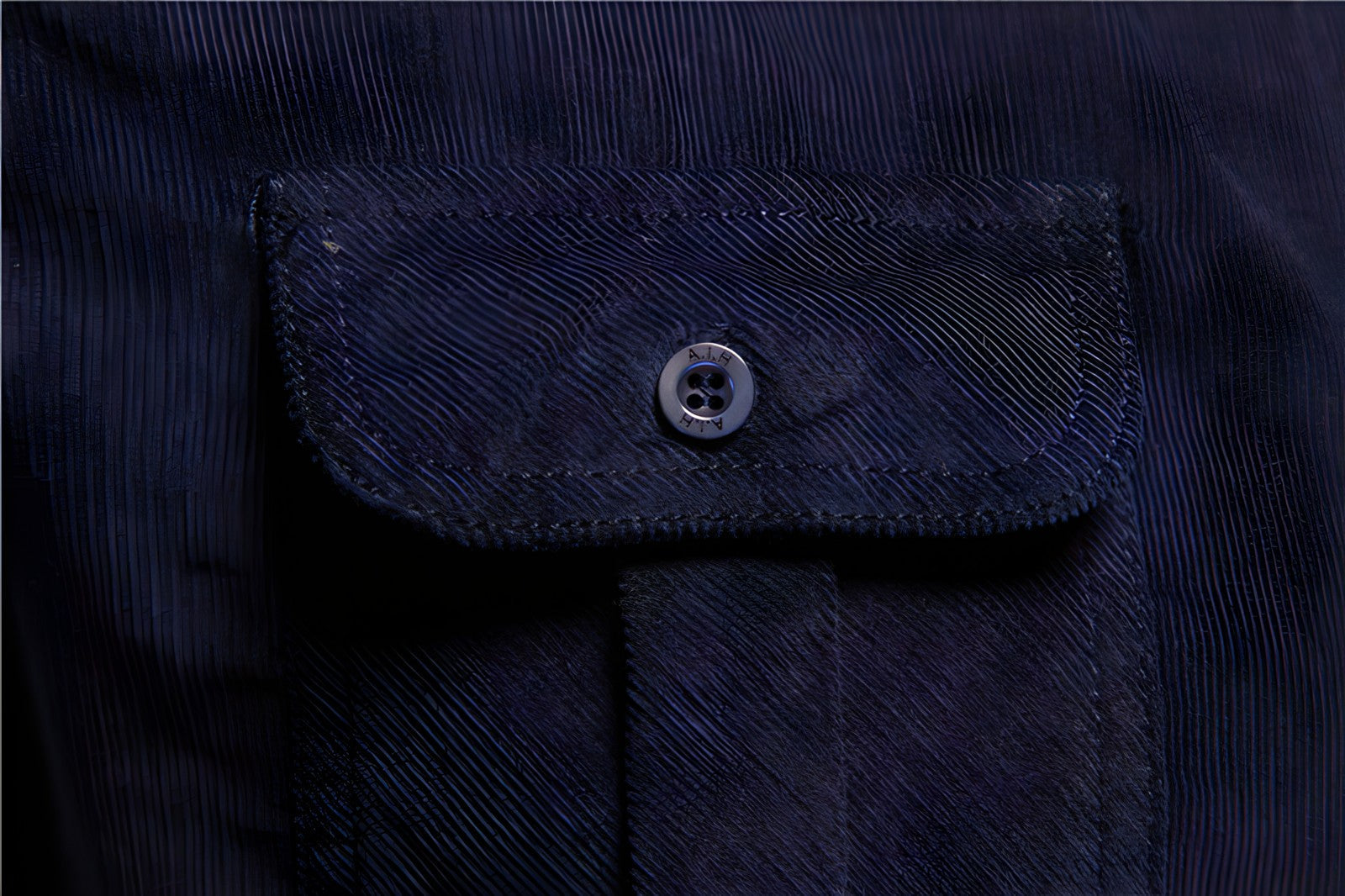 Dunkelblaue Jackentasche mit Knopf, Cordstoff, modisches Design, Detailaufnahme.