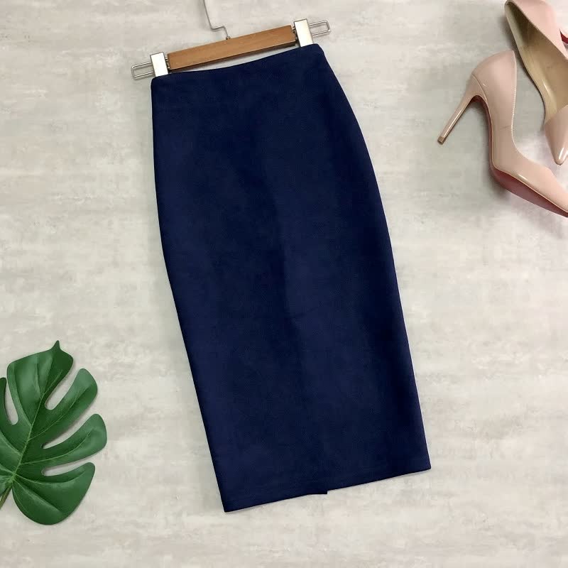 Dunkelblauer Bleistiftrock aus Baumwolle, knielang, neben rosa High Heels und Monstera-Blatt.