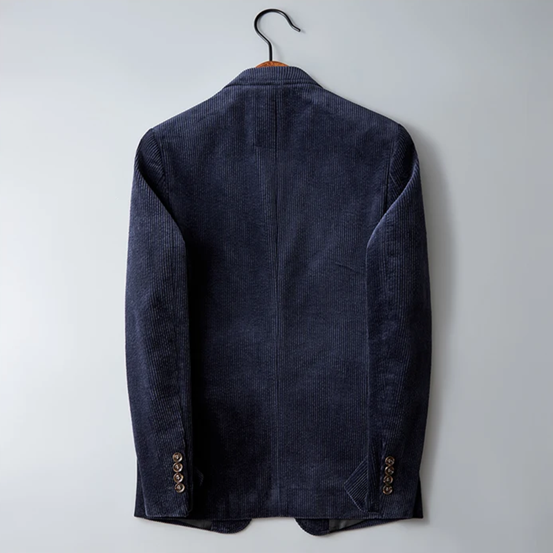 Dunkelblaues Cord-Sakko, Herrenmode, Rückansicht, eleganter Stil, hängend auf Holzkleiderbügel.