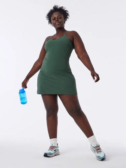 Frau in grünem Sportkleid mit Wasserflasche, Turnschuhe, Fitnessmode, bequem, atmungsaktiv.