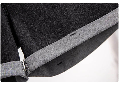 Dunkelgraue Jeansstoff-Detailaufnahme, umgeschlagener Saum, hochwertige Denim-Textur.
