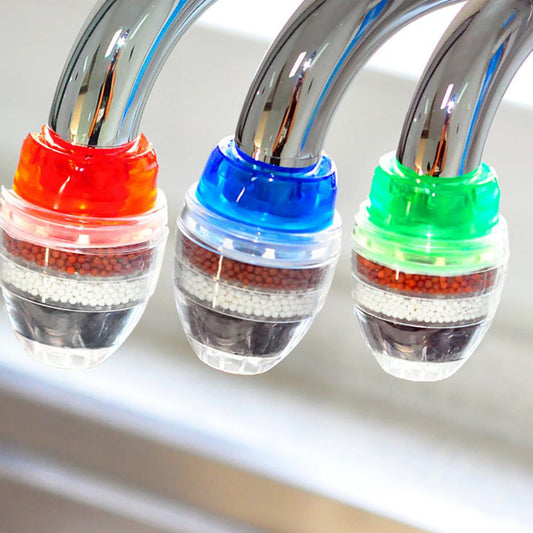 Drei bunte Wasserhahnfilter mit Mineralperlen zur Wasserreinigung, rot, blau, grün.