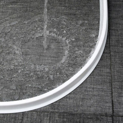 Weiße Duschwanne mit Wasserstrahl, graue Fliesen, modernes Badezimmerdesign.