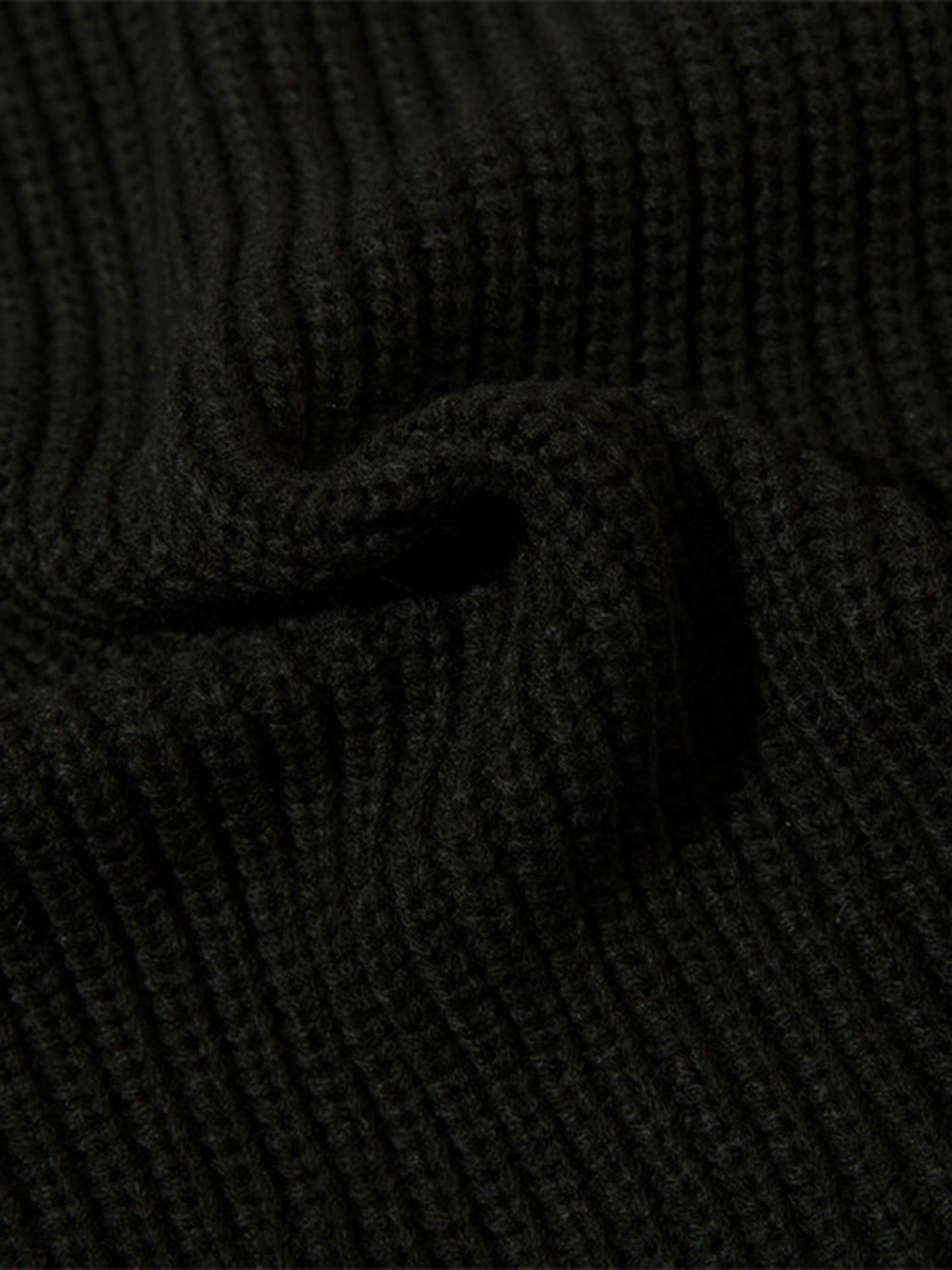 Schwarzer Strickstoff, gerippt, Nahaufnahme, Textur, Mode, Bekleidungsmaterial, Detailansicht.