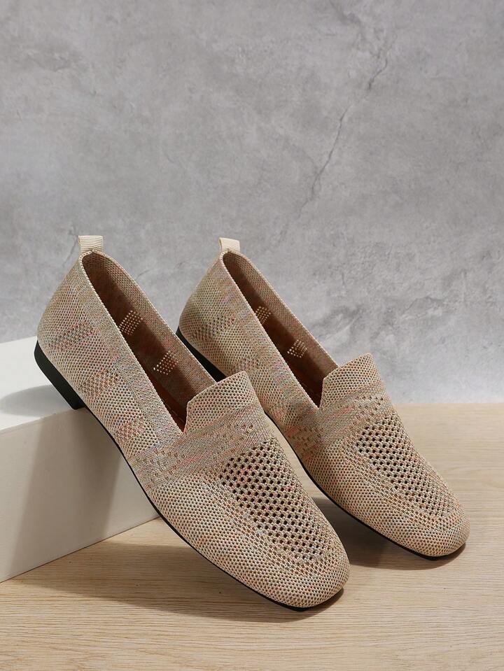 Ett par beige mesh-skor med genombrutet mönster lutade mot en vit låda, med dragflik bak, mot en grå väggbakgrund. 7