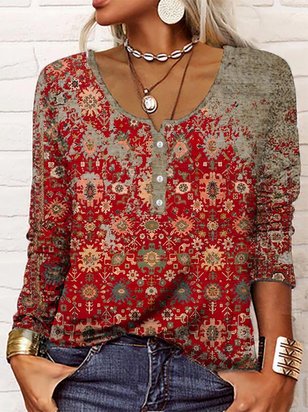 Frau in rotem, gemustertem Langarmshirt, Jeans, Schmuck, modisch, lässig, Boho-Stil.