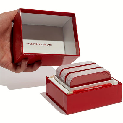 Rotes Kartenspiel-Set "We're Not Really Strangers" in offener Box, Hand hält Deckel.
