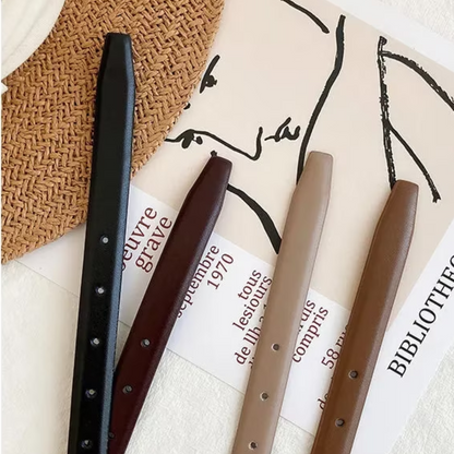 Luxus Ledergürtel in Schwarz, Braun und Beige auf Zeitschrift, stilvolles Accessoire.