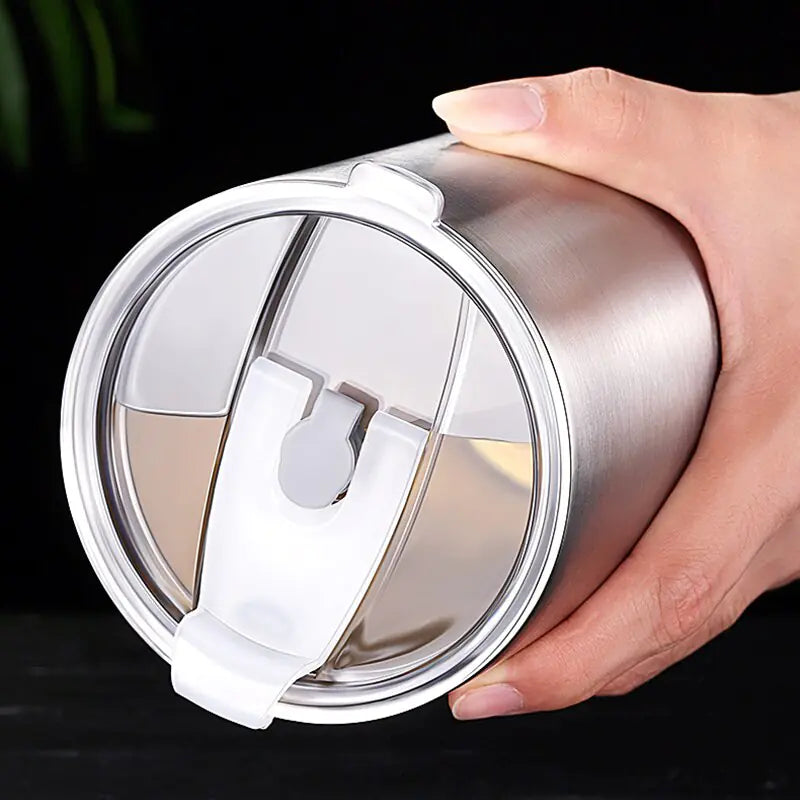 Hand hält silbernen Edelstahl-Thermobecher mit Deckel, isoliert, wiederverwendbar, umweltfreundlich.