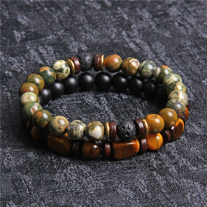 Zwei Armbänder aus Naturstein und Holzperlen, grün und braun, auf schwarzem Hintergrund.